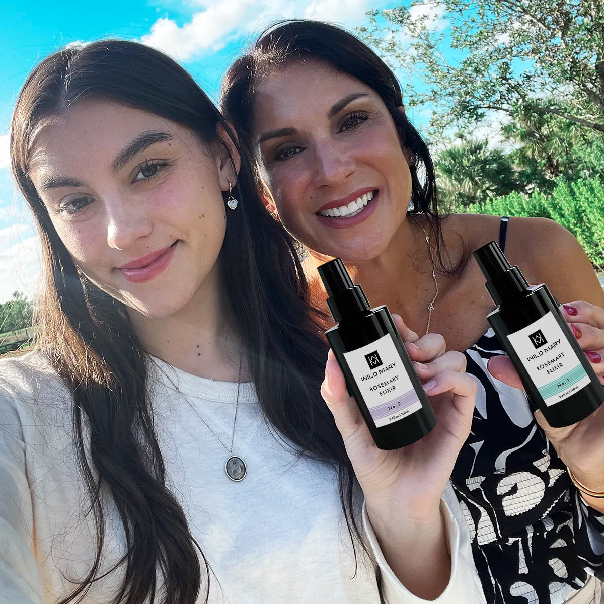 Lily and Maria holding Wild Mary Rosemary Elixir No. 2 Lavender and No. 1 Rosemary.