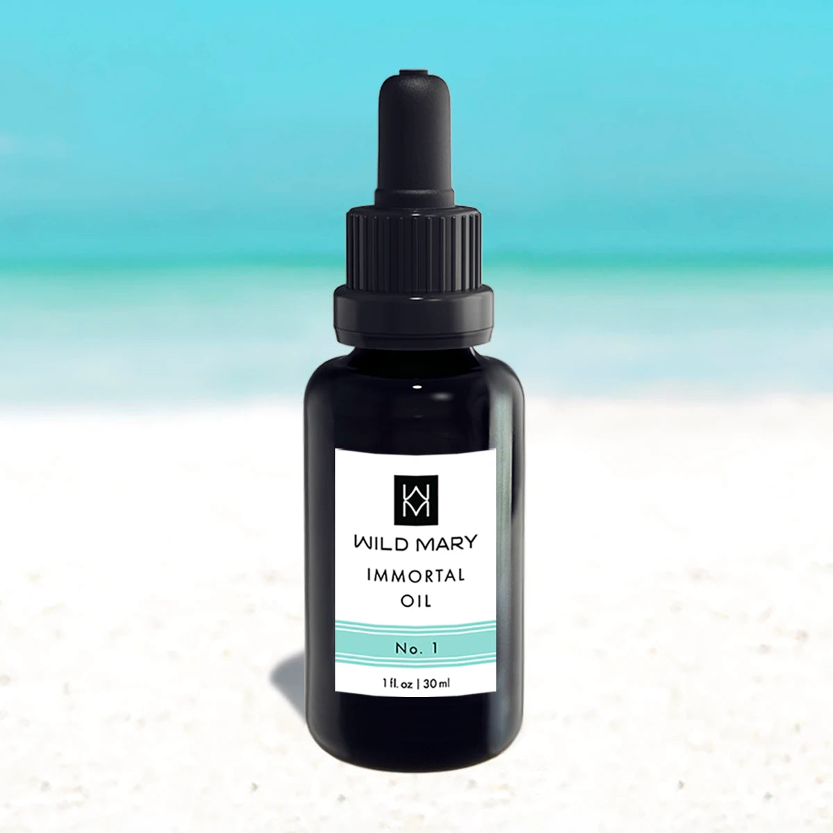 Wild Mary Immortal Oil No. 1 Rosemary Restorative Face Oil in a black glass dropper bottle on Holbox Island beach