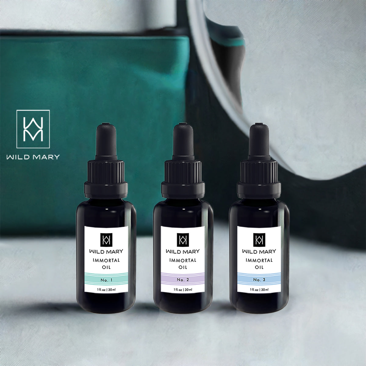 Wild Mary Immortal Oil Trio featuring No. 1 Rosemary, No. 2 Lavender, and No. 3 Rosemary Mint Restorative Face Oils on a vanity.