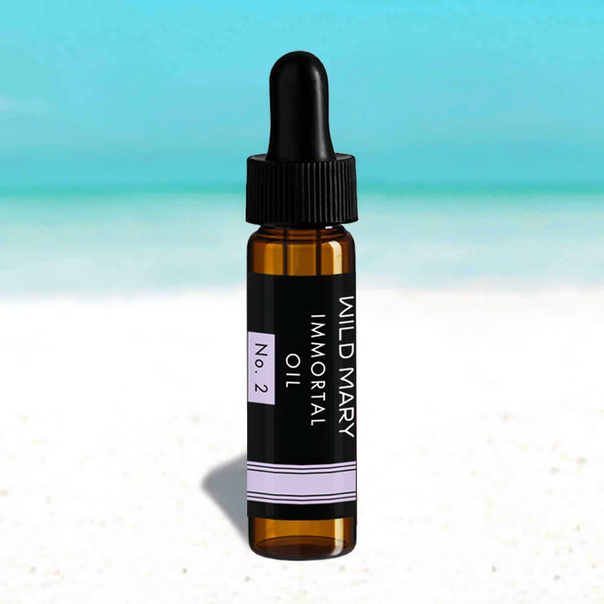 Wild Mary Mini Immortal Oil No. 2 Lavender Restorative Face Oil in a black glass dropper bottle on Holbox Island beach