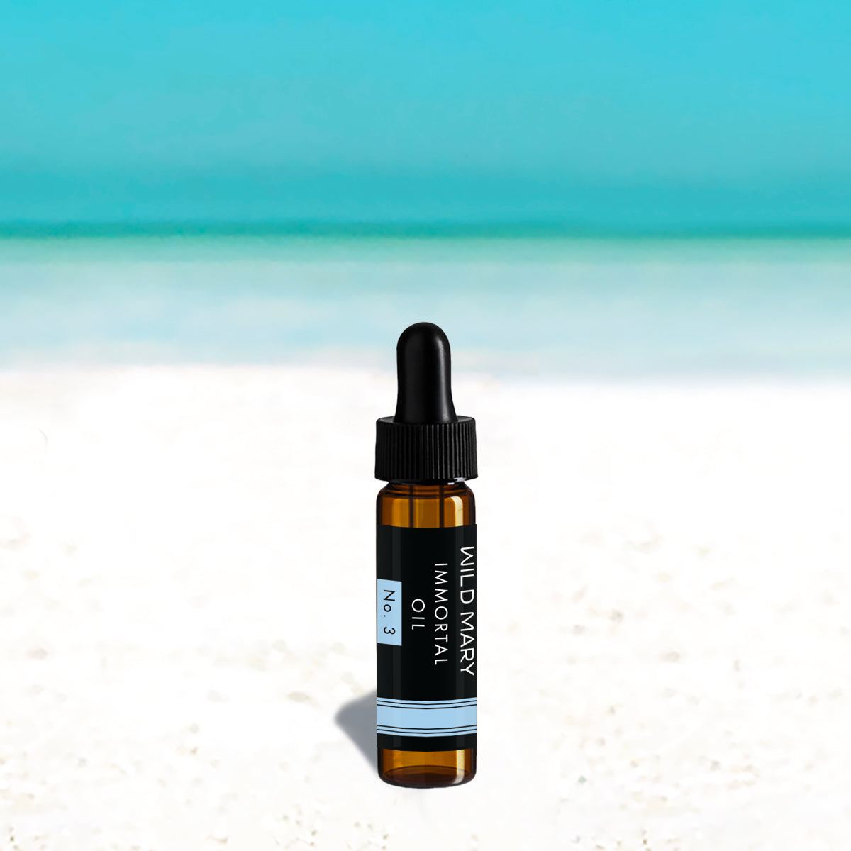 Wild Mary Mini Immortal Oil No. 3 Rosemary Mint Restorative Face Oil in a black glass dropper bottle on Holbox Island beach