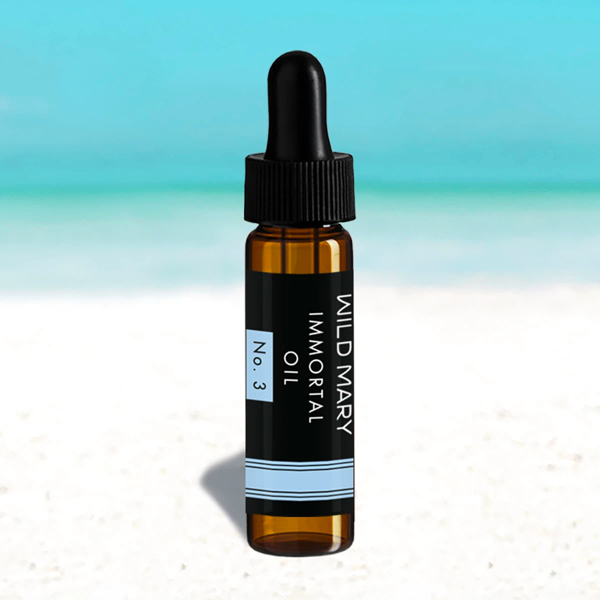 Wild Mary Mini Immortal Oil No. 3 Rosemary Mint Restorative Face Oil in a black glass dropper bottle on Holbox Island beach