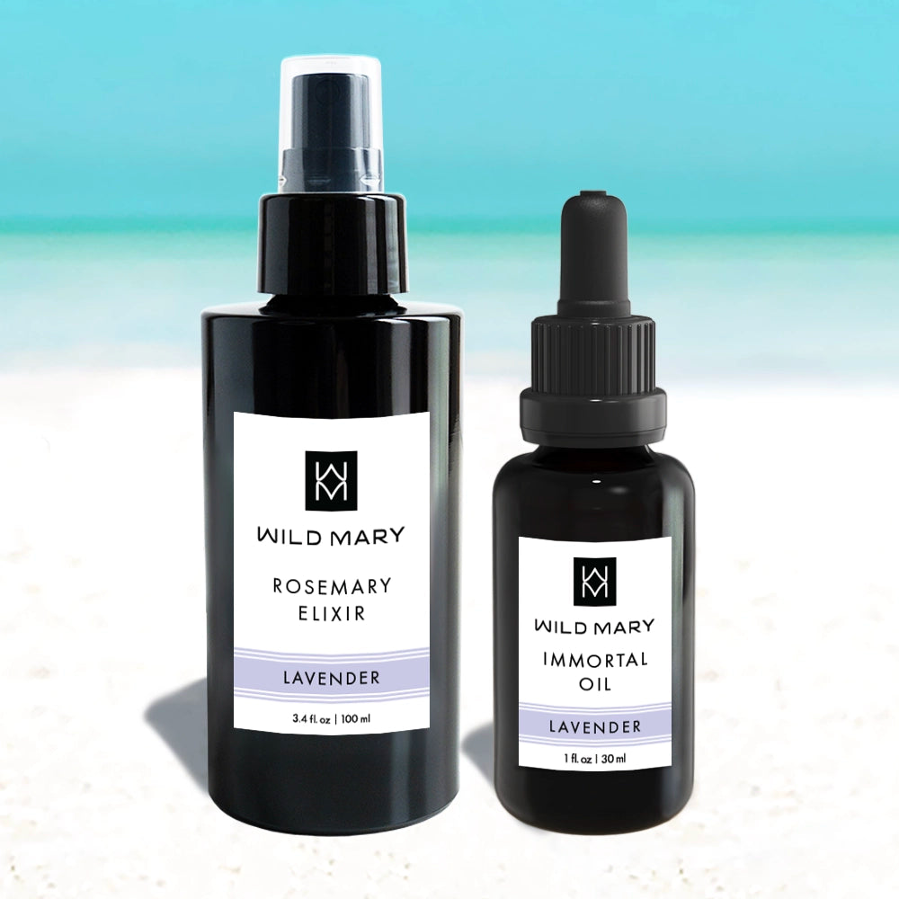 Wild Mary Rosemary Elixir (Lavender) and Immortal Oil (Lavender) skincare bottles on a beach background with light blue and white gradient.